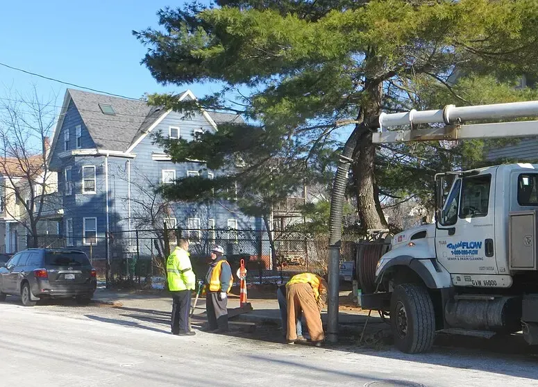 Utility crew and work truck on a residential street during sewer line work